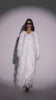 Model wearing a white embroidered bridal abaya walking toward the camera, showcasing side views, back detailing, sleeve close-ups, and ending with a confident look into the camera while wearing sunglasses