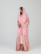 Side view of model in RUMI pink floral abaya with pink sheila scarf, showing front pleats and sleeves