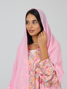 Close-up of model in pink silk floral abaya with matching pink chiffon sheila draped over her head